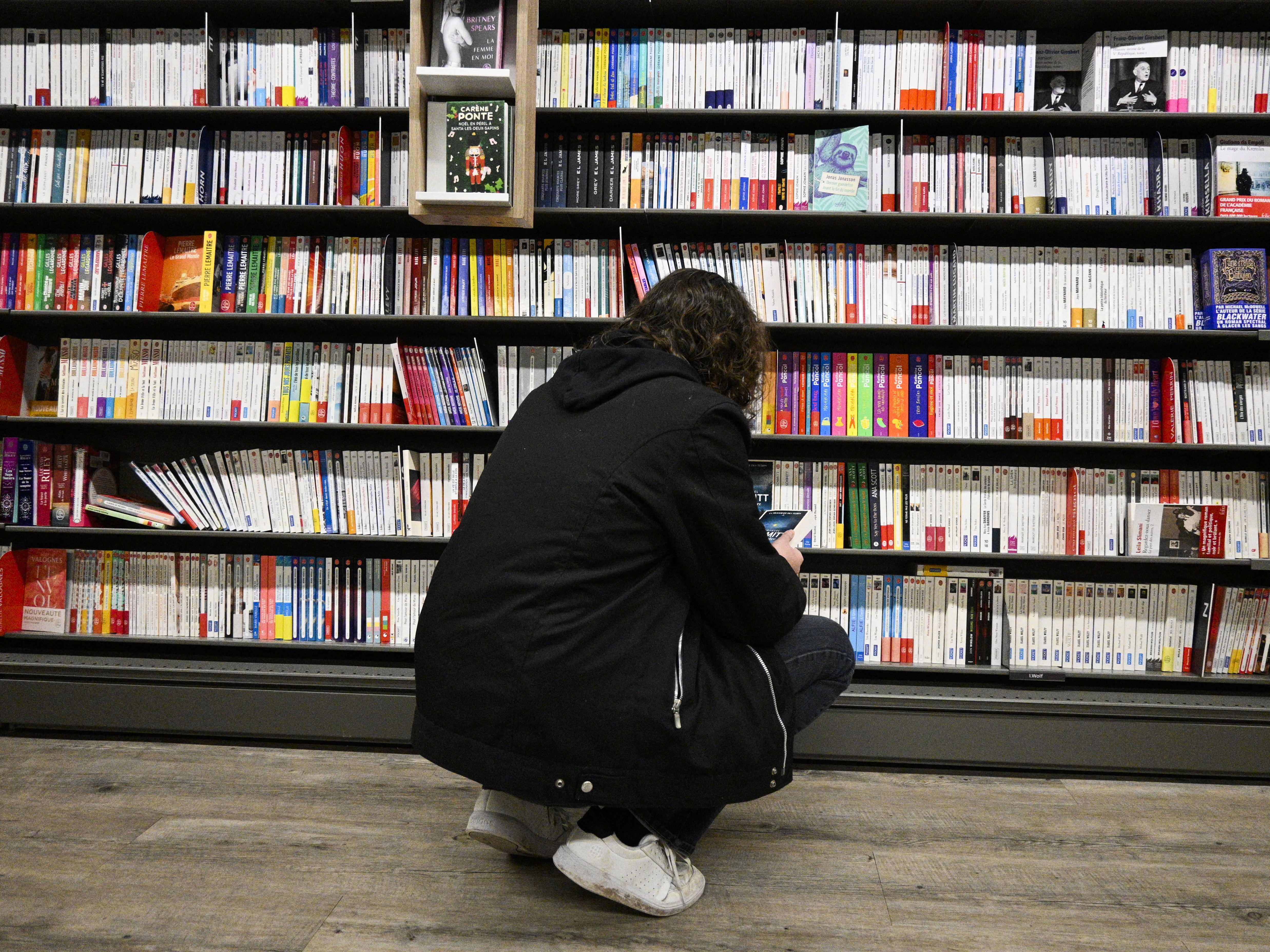 A woman looks at books in a library in 2024.