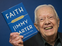 Former U.S. President Jimmy Carter holds up a copy of his book <em>Faith: A Journey For All</em> at a book signing event at Barnes & Noble bookstore on March 26, 2018.